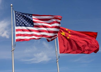 Symbolic of Sino-American relations, the flag of the United States of America and the flag of the Republic of China fly together on flag poles next to each other on a sunny, windy day.