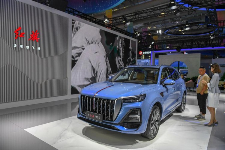 (230828) -- CHANGCHUN, Aug. 28, 2023 (Xinhua) -- A visitor watches a car displayed by FAW Hongqi during the 14th China-Northeast Asia Expo in Changchun, northeast China's Jilin Province, Aug. 23, 2023. (Xinhua/Zhang Nan)