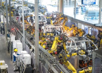 (240402) -- WUHAN, April 2, 2024 (Xinhua) -- A worker works at an assembly line of Voyah, a Chinese luxury electric auto brand, in Wuhan, central China's Hubei Province, April 1, 2024. In recent years, Wuhan enhanced its research ability on energy saving and carbon reduction technologies, aiming to upgrade the automobile industry with technological innovation. (Xinhua/Xiao Yijiu)