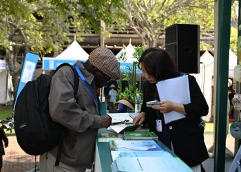 (250725) -- VICTORIA FALLS, July 25, 2025 (Xinhua) -- A participant inquires about China's wetland conservation efforts from a staff member outside the China Pavilion during the 15th Meeting of the Conference of the Contracting Parties to the Ramsar Convention on Wetlands (COP15) in Victoria Falls, Zimbabwe, on July 23, 2025. The 15th Meeting of the Conference of the Contracting Parties to the Ramsar Convention on Wetlands (COP15) opened on Thursday in Zimbabwe's resort city of Victoria Falls, with a call for international cooperation in the global wetland preservation. (Xinhua/Xu Zheng)